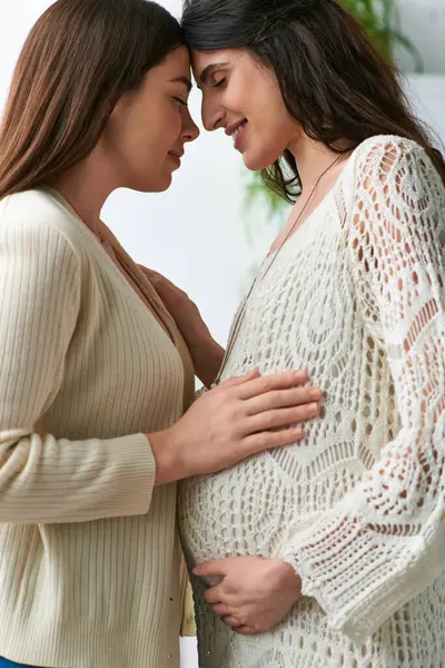 Expecting lesbian couple hugging lovingly and touching foreheads, in vitro fertilisation concept — Stock Photo
