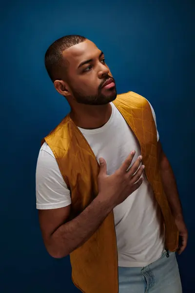 Hombre afroamericano guapo con barba mirando hacia otro lado con la mano en el pecho, concepto de moda — Stock Photo