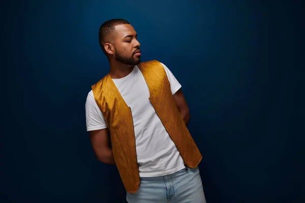 Jovem homem americano africano em elegante colete amarelo posando dobrando para o lado, conceito de moda — Fotografia de Stock