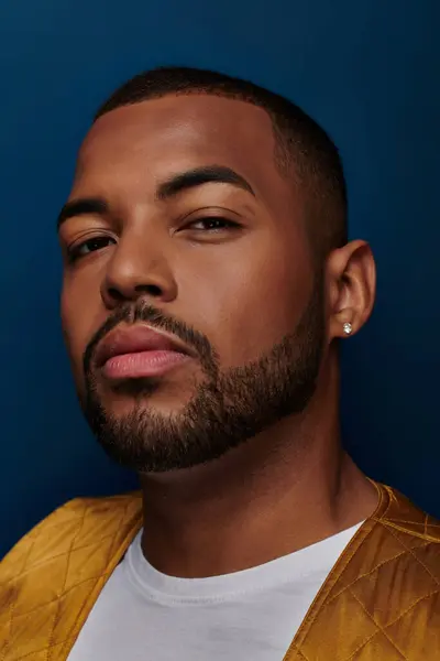 Modèle masculin afro-américain à la mode avec barbe et boucle d'oreille en diamant regardant la caméra, concept de mode — Photo de stock