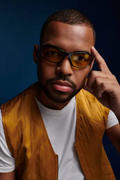 Portrait of young man in glasses with beard and finger near face looking at camera, fashion concept — Stock Photo