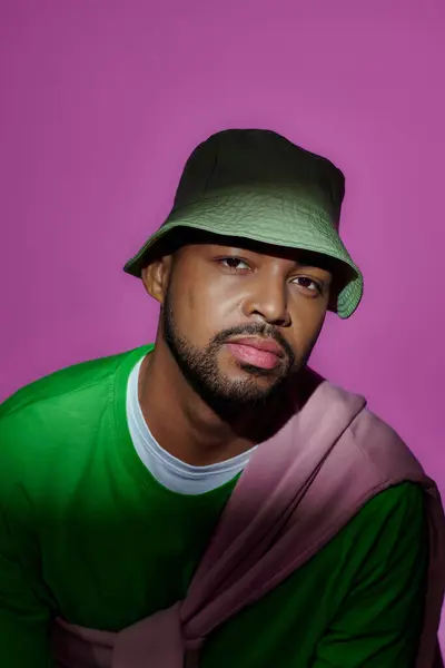 Handsome trendy man in green panama with purple shirt tied on his shoulders, fashion concept — Stock Photo