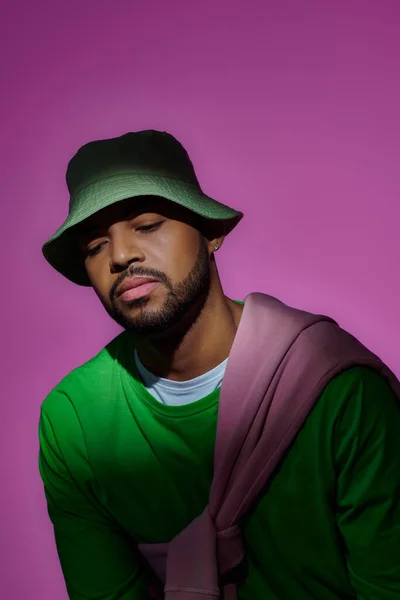 Young african american male model with earring and sweatshirt tied on his shoulders, fashion concept — Stock Photo