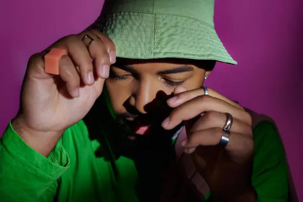 Close up of young handsome man with rings on fingers touching green panama, fashion concept — Stock Photo