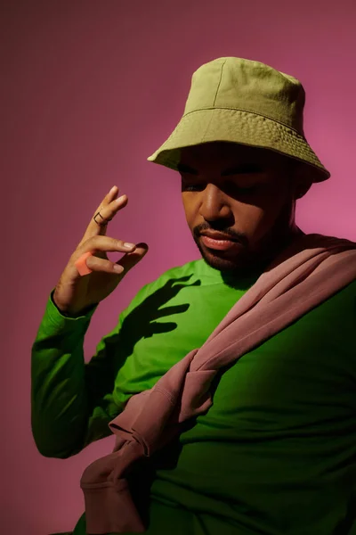 Trendiger bärtiger Mann mit Ringen an den Fingern, der vor rosa Hintergrund aktiv gestikuliert, Modekonzept — Stockfoto