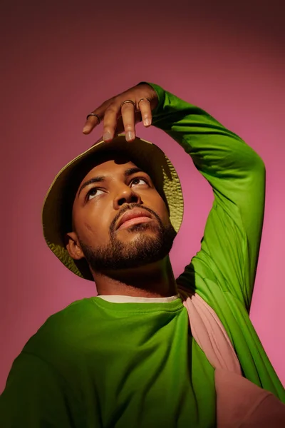 Good looking african american man with silver rings in green panama gesturing, fashion concept — Stock Photo