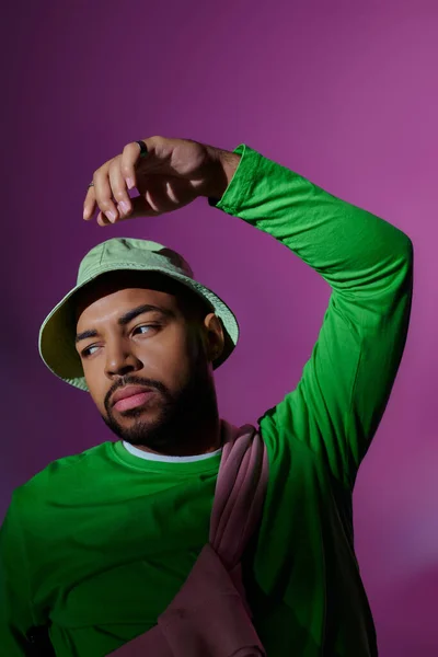 Young bearded male model in stylish casual attire posing on purple backdrop, fashion concept — Stock Photo