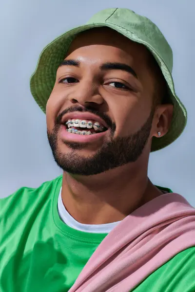 Портрет веселого молодого человека в стильной Панаме с брекетами счастливо улыбаясь, концепция моды — стоковое фото