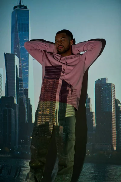 Handsome african american man standing by the wall with hands crossed behind head, fashion concept — Stock Photo