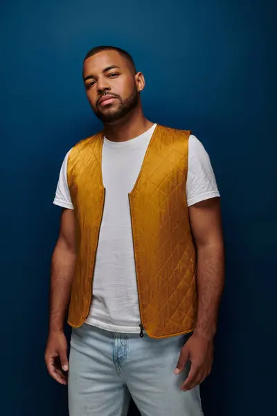 Молода афроамериканська чоловіча модель з бородою і сережкою в модному жовтому жилеті, концепція моди — стокове фото