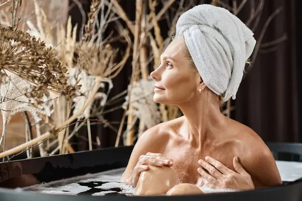 Relaxado mulher de meia idade com toalha branca na cabeça tomando banho no apartamento moderno, dia de spa — Fotografia de Stock