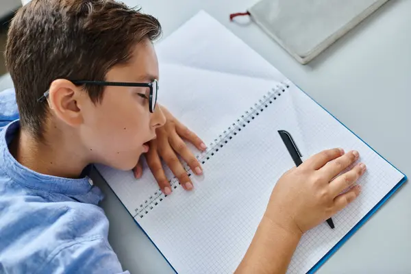 Tired boy in glasses sleeping during lesson — Stock Photo