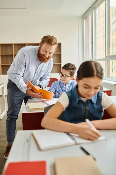 Un uomo in piedi ad una scrivania, che insegna a un gruppo di studenti in una vibrante classe. — Foto stock