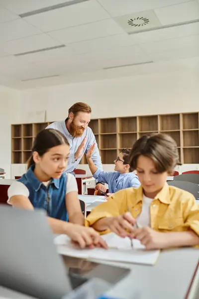 A group of people, including a man teacher, sitting at desks in a bright, lively classroom, engaging in a lesson. — Stock Photo
