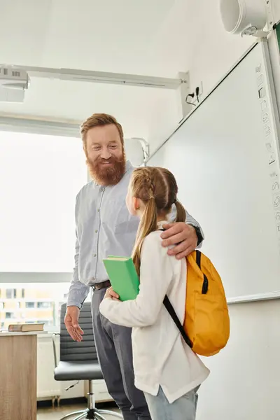 Un uomo e una bambina in piedi davanti a una lavagna bianca in un ambiente luminoso e vivace in classe, impegnati in una sessione di apprendimento creativo. — Foto stock