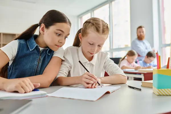 Deux jeunes filles sont assises à une table, immergées dans leurs livres, alors qu'elles se concentrent sur la lecture et l'apprentissage.. — Photo de stock