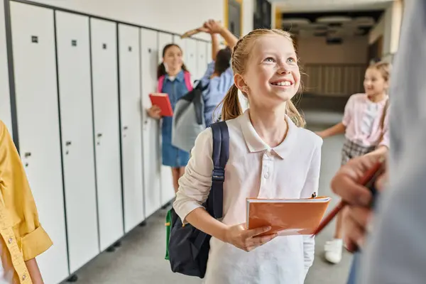 A group of children, diverse in appearance, stand in a hallway next to colorful lockers. — Stock Photo