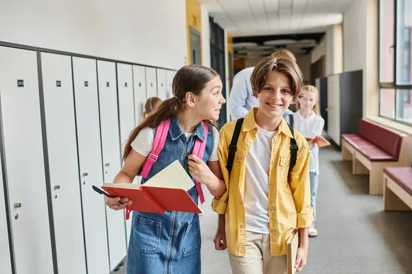 Un couple d'enfants marchant énergiquement dans le couloir, leurs visages remplis d'excitation et de curiosité alors qu'ils explorent l'environnement scolaire. — Photo de stock