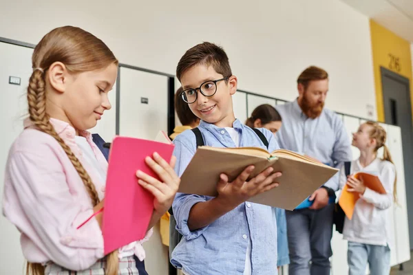 Un grupo de niños están uno al lado del otro en un salón de clases luminoso y animado, mientras su maestro observa. — Stock Photo