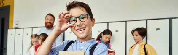 Un giovane uomo con gli occhiali si trova fiducioso davanti a armadietti colorati, trasudando un'aria di conoscenza e autorità.. — Foto stock