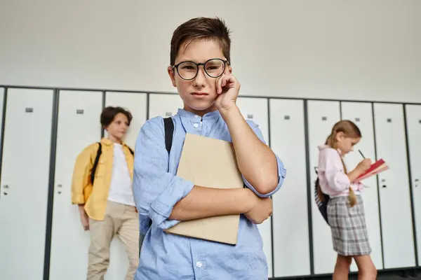 A boy in a blue shirt stands amidst rows of lockers in a school hallway. — Stock Photo