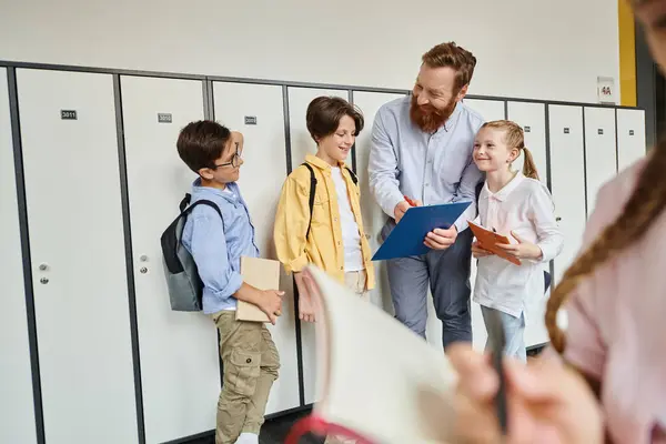 Учитель-мужчина инструктирует разнообразную группу детей в яркой, живой обстановке в классе, с шкафчиками на заднем плане. — стоковое фото