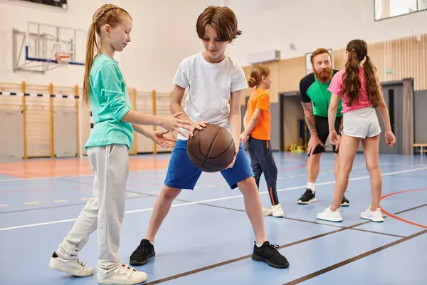 Un grupo diverso de niños pequeños jugando baloncesto con entusiasmo y energía en un entorno vibrante. - foto de stock