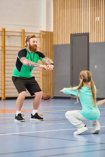 A man and a little girl are immersed in physical education class in school gym — Stock Photo