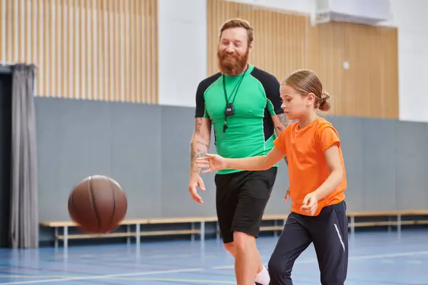 Un hombre y una niña están disfrutando de un partido de baloncesto juntos.. - foto de stock