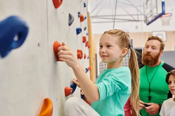 Professor e crianças, reunidos em torno de uma parede de escalada colorida, envolvidos na escalada e receber instruções — Fotografia de Stock