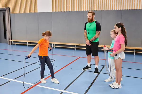 A man and young girls sharing laugh during physical education class — Stock Photo