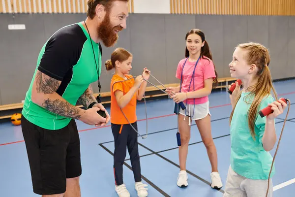 Un insegnante di sesso maschile si trova di fronte a un gruppo eterogeneo di bambini in un'aula luminosa e vivace, coinvolgendoli nell'apprendimento e nell'istruzione.. — Foto stock