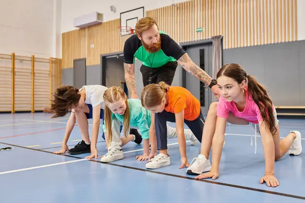 Um grupo diversificado de crianças está se engajando em uma sessão sincronizada de flexões em um chão de ginástica, guiada por seu instrutor. — Fotografia de Stock