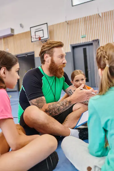 A diverse group of kids sitting attentively around their teacher in a bright, lively classroom setting. — Stock Photo