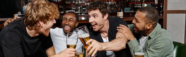 Баннер взволнованных мультикультурных друзей, звенящих с бокалами пива в баре, мужчин на мальчишнике — стоковое фото