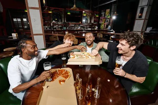 Groupe de quatre amis multiethniques partageant une pizza et buvant de la bière au bar, hommes en enterrement de vie de garçon — Photo de stock