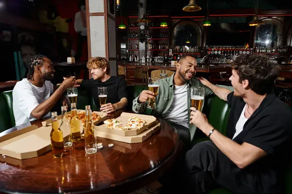 Щасливі міжрасові друзі чоловічої статі спілкуються піцою і келихами пива в барі, чоловіки на дівич-вечірці — Stock Photo