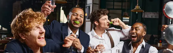 Banner of four happy and drunk multiethnic friends in formal wear drinking tequila in bar after work — Stock Photo