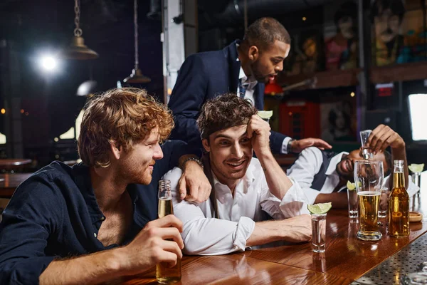 Betrunkene männliche Freunde unterhalten sich nach dem Trinken von Tequila und Bier in der Bar, verbringen Zeit nach der Arbeit — Stockfoto