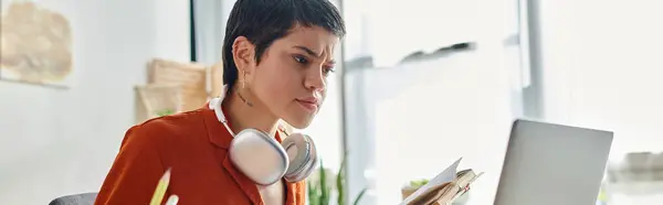 Concentrated brunette female student holding mobile phone and looking at laptop, education, banner — Stock Photo