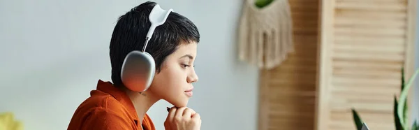 Estudiante de pelo corto con auriculares que estudian atentamente durante la clase en línea, la educación, la pancarta - foto de stock