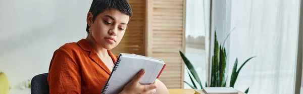 Estudiante trabajadora en ropa de casa mirando atentamente sus notas, educación en casa, pancarta - foto de stock