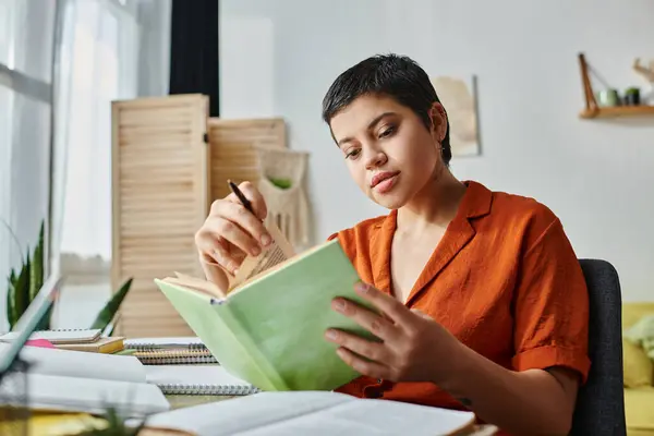 Attractive young woman with short hair and tattoo on neck studying hard at home, education — Stock Photo