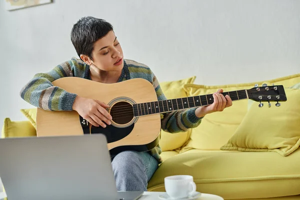 Concentrated attractive woman learning how to play guitar on remote lesson, education at home — Stock Photo
