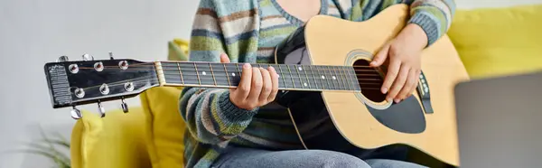 Vista recortada de la mujer sentada delante de la computadora portátil aprender a tocar la guitarra en clase remota, bandera - foto de stock