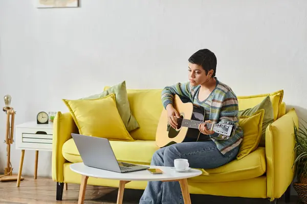 Focalisé femme attrayante en tenue décontractée apprendre à jouer de la guitare sur la leçon de musique à distance — Photo de stock