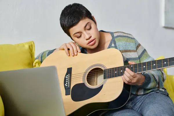 Concentrated young woman learning how to play guitar on remote music lesson, education at home — Stock Photo