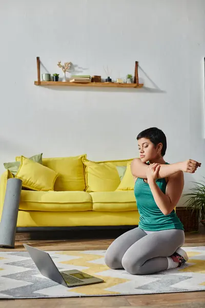 Vertikale Aufnahme einer jungen Frau in Sportkleidung beim Stretching während eines Online-Fitnessunterrichts, Fitness — Stockfoto