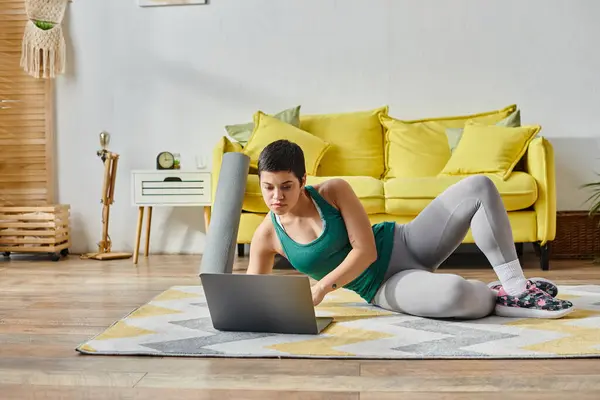 Concentrated woman in sportswear preparing to exercise during online fitness class, fitness — Stock Photo