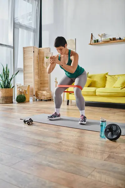 Vertikale Aufnahme einer athletischen Frau mit kurzen Haaren, die mit Widerstandsband, Fitness und Sport trainiert — Stockfoto